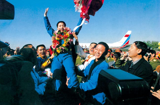 2003年10月16日 執(zhí)行神舟五號任務航天員楊利偉返回西郊機場被歡呼的人群拋起 攝影:朱九通