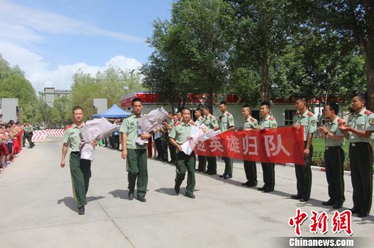 部隊官兵們迎接出院歸來的李運飛(中)和其他消防戰(zhàn)士?！⊥粲?攝