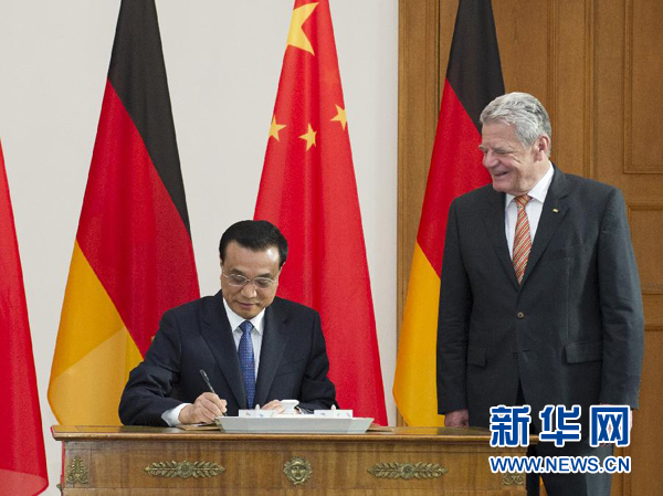 10月10日，國務(wù)院總理李克強在柏林會見德國總統(tǒng)高克。這是李克強總理在高克總統(tǒng)的陪同下在貴賓簿上簽字。 新華社記者 王曄 攝 