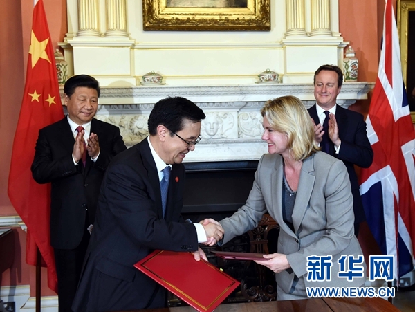 10月21日，國家主席習近平在倫敦唐寧街首相府同英國首相卡梅倫舉行會談。這是會談結(jié)束后，兩國領導人共同見證雙邊合作文件的簽署。新華社記者 饒愛民 攝 